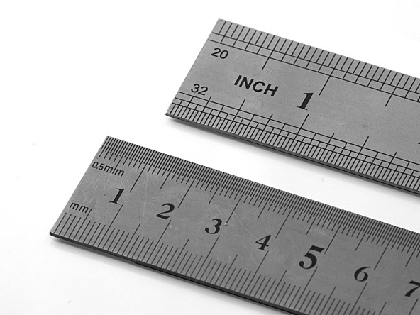 two grey rulers displaying different scales